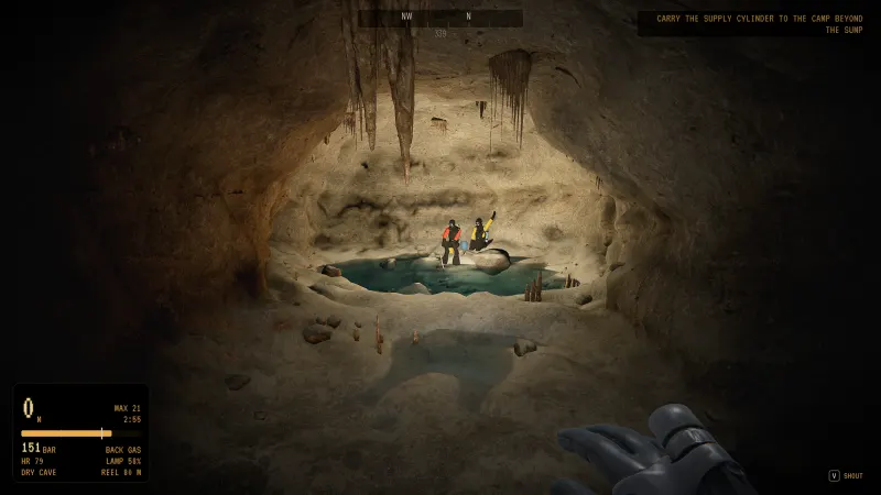 A dry camp beyond a sump, two expedition members by the water